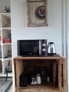 microondas en un soporte de madera en la sala de estar en StarFish Accommodation, en Struisbaai