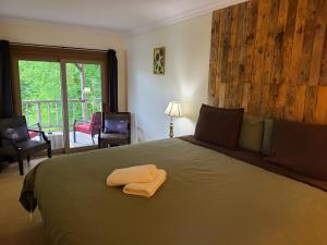 a bedroom with a bed with two towels on it at Le Lodge du lac in Saint-Faustin