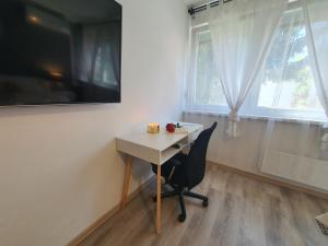 a desk and a chair in a room with a window at Aparman Jež 3 De Lux in Karlovac