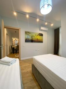 1 dormitorio con 2 camas y sala de estar en Centrally located Glamorous Bright APT near Bazaar, en Tirana