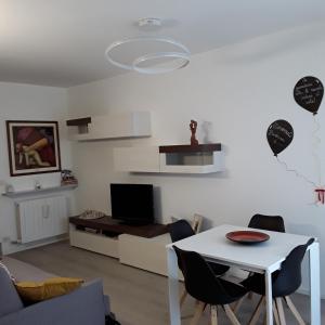 a living room with a white table and chairs at OLTRE LE NUVOLE in Cuneo