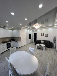 a kitchen and living room with a white table and chairs at Kobi Apartments in Tbilisi City