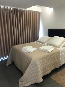 um quarto com uma cama com toalhas em Apartamento Deluxe AM em Faro