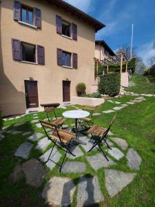 una mesa y sillas frente a un edificio en Casa di vacanza in Capriasca ( Lugano ), en Bidogno