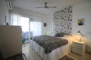 a bedroom with a bed with a zebra patterned blanket at Relax en el Rincón de la Victoria in Rincón de la Victoria