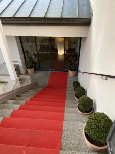 un tapis rouge sur les escaliers d'un immeuble dans l'établissement Les Suites du Lac, à Aix-les-Bains