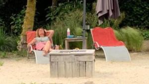 een vrouw in een stoel op het strand bij B&B. Het Hunebed Rolde in Rolde