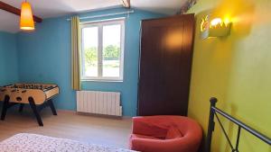 1 dormitorio con 1 cama, 1 silla y 1 ventana en Le bois de l'étang - Gîte 3 étoiles - 6 pers, 