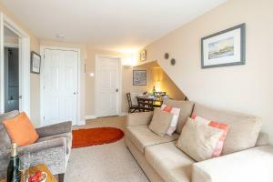 a living room with a couch and a table at The Haven at Coastguard Court - Aldeburgh Coastal Cottages in Aldeburgh +13 photos
