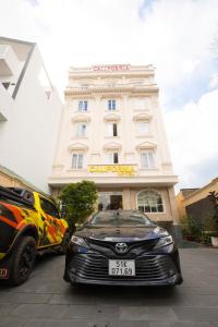 dos coches estacionados frente a un edificio en California Hotel, en Ho Chi Minh