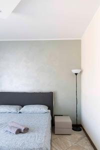 ein Schlafzimmer mit einem Bett und einer weißen Wand in der Unterkunft BLUE LAKE ARONA - cozy apartment in city center in Arona