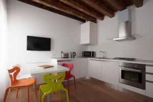 ヴェネツィアにあるザ ライオンズ ハウス APT1のキッチン(カラフルな椅子、小さなテーブル付)