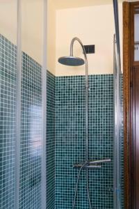 um chuveiro numa casa de banho com azulejos verdes em BLUE LAKE ARONA - cozy apartment in city center em Arona