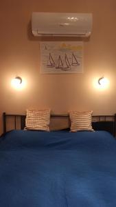 Un dormitorio con una cama azul con dos almohadas. en City Lights Apartman, en Keszthely