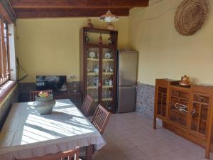 uma cozinha com uma mesa e um frigorífico em Sa domu 'e pisittu em Iglesias