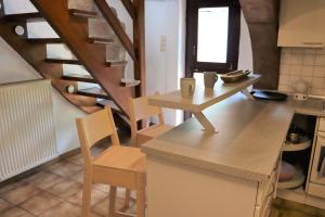 een keuken met een tafel en stoelen en een trap bij Ferienwohnung, Charmantes Bauernhaus, Ferienhaus in Saarlouis