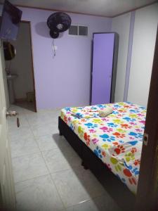 a bedroom with a bed with a colorful comforter at montecarlos hotel in Ibagué