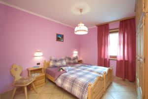 ein Schlafzimmer mit einem Bett, einem Tisch und einem Stuhl in der Unterkunft Baita Ruscello in Livigno