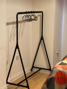 a black iron rack next to a bed in a room at The Court in Stone Grove