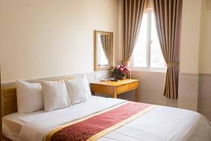 um quarto com uma cama, uma janela e uma mesa em California Hotel em Ho Chi Minh