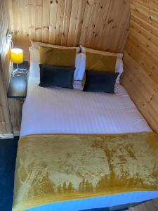 a bed in a room with a wooden wall at Couston Lakes Resorts in Bathgate