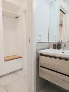uma casa de banho branca com um lavatório e um espelho em La Gardenia em Celano