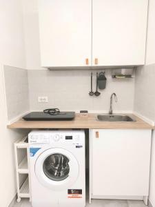 uma cozinha com uma máquina de lavar roupa e um lavatório em La Gardenia em Celano