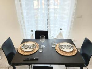 uma mesa preta com dois pratos e taças de vinho em La Gardenia em Celano