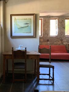 a room with a table and a bench and a bed at Kyparissi Guest House in Paralía Kiparissi