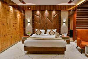 1 dormitorio con 1 cama grande y paredes de madera en Hotel RJ, en Barddhamān