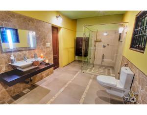 a bathroom with a toilet and a sink and a shower at Costa Verde Luxury Seafront Villa in Chennai