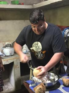 a man is making food in a kitchen at Nature Glow Cottage in Udawalawe