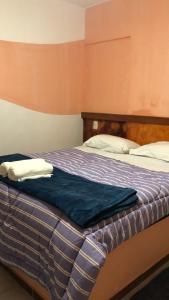 a bed with a blue comforter in a room at Pousada Sitio Roda D'Água Mairinque in Mairinque