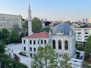 a white building with a mosque in a city at Scope Apartment in Istanbul