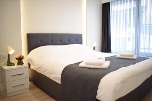 1 dormitorio con 1 cama grande y 2 toallas. en Scope Apartment, en Estambul