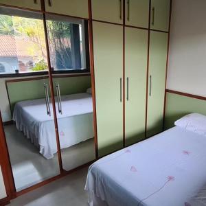 a room with two beds and a large mirror at Suíte Theo in Blumenau
