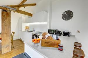 uma cozinha com um balcão com um relógio na parede em Loft 11 - Unique Apartment with Stunning Views em Harrogate