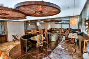Un restaurante con mesas y sillas y un techo. en Hotel RJ, en Barddhamān 50 fotos más