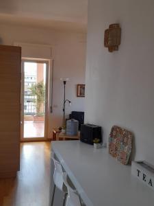 a kitchen with a white counter top and a table at Sea view Penthouse with beautiful Terrace - Casa Verdi Jayanti in Lido di Ostia +30 photos