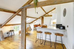 a kitchen with wooden beams and a counter with stools at Loft 11 - Unique Apartment with Stunning Views in Harrogate