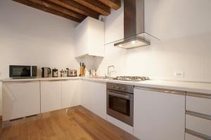 a kitchen with white cabinets and a stove top oven at The Lion's House APT2 in Venice