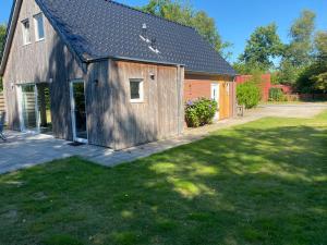 a barn with a grass yard next to a house at Vakantiehuisje drenthe gasselterveld in Gasselte