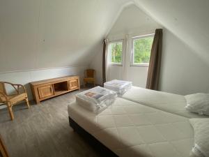 Un dormitorio con una cama grande y una ventana en Vakantiehuisje drenthe gasselterveld, en Gasselte