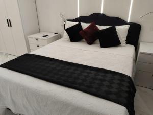Cama grande con sábanas y almohadas blancas y negras en Black & White, en Pietra Montecorvino