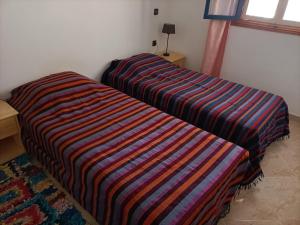 twee bedden naast elkaar in een kamer bij Dar Albatros in Sidi Kaouki