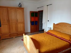 a bedroom with a bed and wooden cabinets at Dar Albatros in Sidi Kaouki