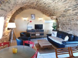 a living room with a couch and a table at Gîte l'Echappée belle in Castelnau-Pégayrols +33 photos