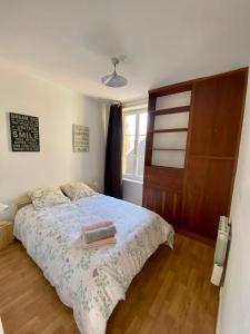 a bedroom with a bed with a wooden floor and a window at Bro’ Flat appartement au calme Cherbourg Centre in Cherbourg en Cotentin
