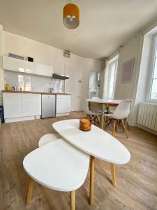 a kitchen with white tables and chairs in a room at Bro’ Flat appartement au calme Cherbourg Centre in Cherbourg en Cotentin