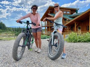 zwei Frauen stehen mit ihren Fahrrädern vor einer Hütte in der Unterkunft Myra Canyon Lodge in Kelowna
